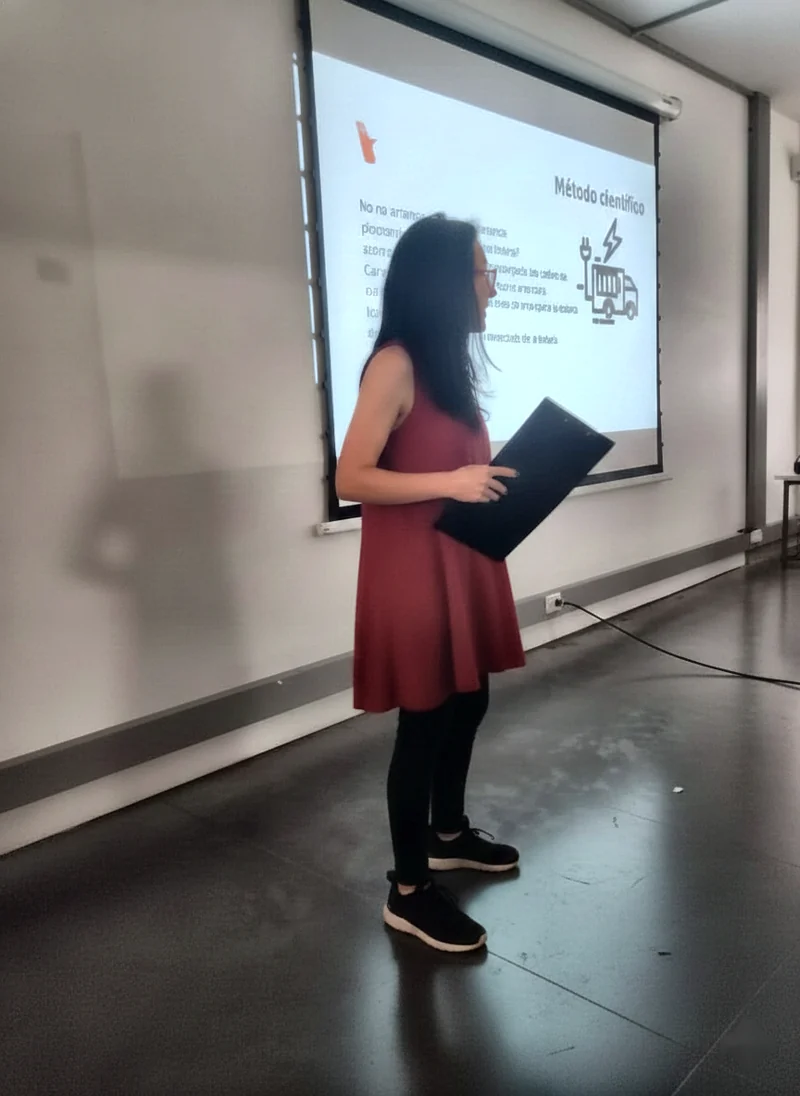 Helena Cortés dando una charla frente a una proyección